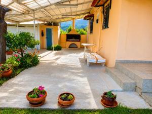 a patio with three potted plants and a bench at Vicky's Sweet Home - Seaside Retreat in Evia in Agia Anna