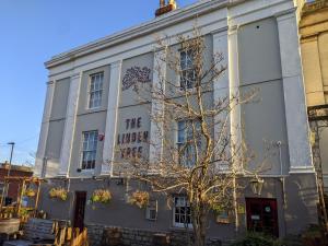 a white building with a tree in front of it at The Linden Tree in Gloucestershire