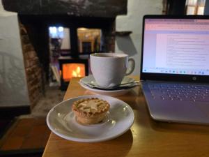 a cupcake on a plate next to a laptop computer at The Linden Tree in Gloucestershire