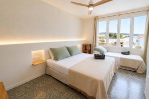a bedroom with two beds and a window at Hotel S'Algaret in Fornells