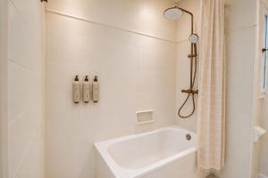 a white bathroom with a tub and a shower at Hotel S'Algaret in Fornells +16 photos