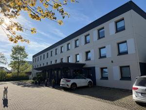 a white car parked in front of a building at ibis budget Muenchen Putzbrunn in Putzbrunn