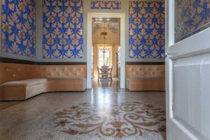 a living room with blue and white wallpaper and a hallway at Villa Ciccarese in Cursi