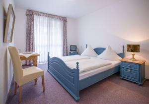 a bedroom with a bed and a desk and a chair at Gästehaus Urschel in Bad Kreuznach +1 photo