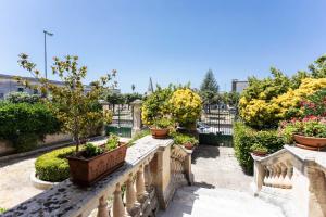 a garden with potted plants on a stone railing at Villa Ciccarese in Cursi