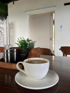 a cup of coffee sitting on a wooden table at Hotel Nivasa, Narkanda in Nārkanda +23 photos