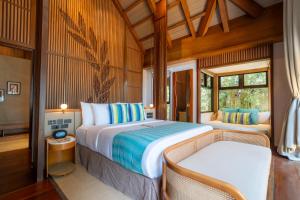 a bedroom with a large bed and a chair at Ma'oni Seascape Villas in Panglao Island