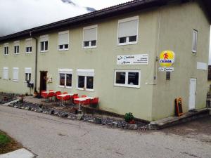 a building with red chairs in front of it at La Cantina Restaurant in Alvaneu