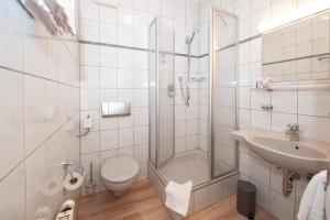 a bathroom with a shower and a toilet and a sink at Hotel Bären in Schramberg