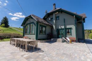 a house with a table and chairs in front of it at Gorski park Kupjak in Kupjak