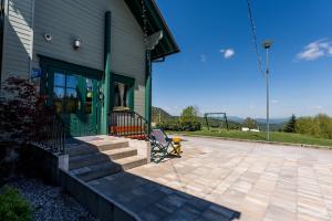 a house with a porch with a playground next to it at Gorski park Kupjak in Kupjak +55 photos