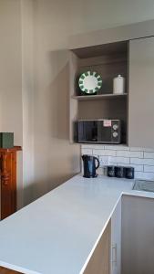 a kitchen with a counter and a clock on the wall at Glen Lilly Self Catering in Parow
