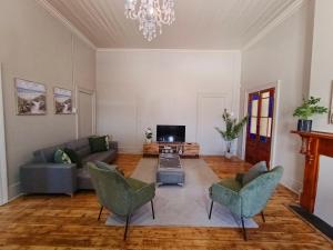 a living room with a couch and chairs and a tv at Glen Lilly Self Catering in Parow