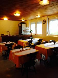 ein Restaurant mit Tischen und Stühlen in einem Zimmer in der Unterkunft La Cantina Restaurant in Alvaneu