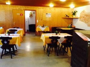 a restaurant with tables and chairs with yellow table cloth at La Cantina Restaurant in Alvaneu