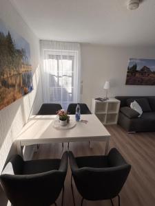 a living room with a white table and chairs at Heideglück in Visselhövede