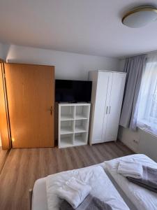 a bedroom with a bed and a cabinet and a television at Heideglück in Visselhövede