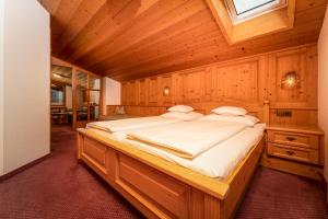 a bedroom with a large bed in a wooden room at Alpenhof Wohlfühlpension in Obsteig