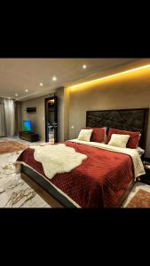 a large bedroom with a large bed with red sheets at Villa luxueuse in Tipaza