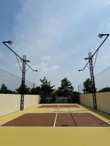 a tennis court with lights on top of it at Cuchi Downtown in Xóm Bến Cỏ