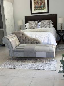 a bedroom with a bed and a couch and a bed at Modern & Stylish Bachelor Flat in Burgersdorp