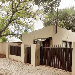 a house with a gate and a fence at Modern & Stylish Bachelor Flat in Burgersdorp