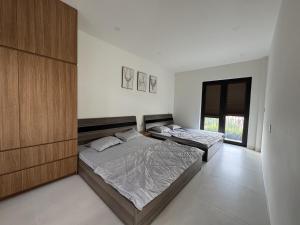 a bedroom with two beds and a large window at Cuchi Downtown in Xóm Bến Cỏ