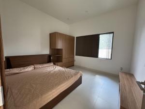 a bedroom with a bed and a flat screen tv at Cuchi Downtown in Xóm Bến Cỏ +7 photos