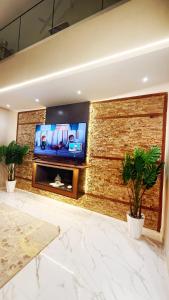 a living room with a tv on a brick wall at Villa luxueuse in Tipaza