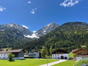 a village in the mountains with snow covered mountains at Ferienwohnung Heiterwang in Heiterwang