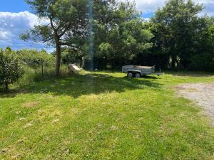 a truck parked in a field next to a tree at Chambre in Saint-Pierre-dʼAurillac