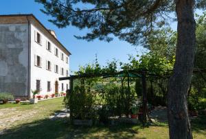 a garden with a pergola next to a building at B&B Antica Fonte del Latte in Santa Vittoria in Matenano