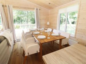 a dining room with a wooden table and white chairs at Kingfisher in Ross on Wye +14 photos