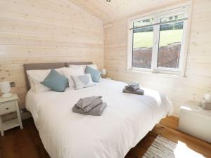 a bedroom with a large white bed with towels on it at Kingfisher in Ross on Wye