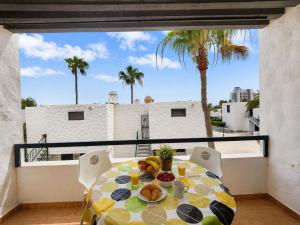 a table with a plate of food on a balcony at Fwt Relax Bungalow in Playa de las Americas