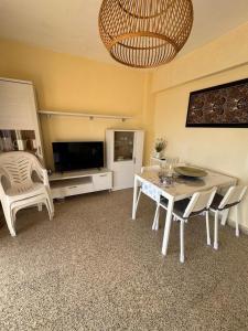 a living room with a table and chairs and a television at Brisa azul in Torrenueva +2 photos