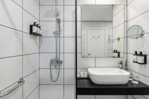 a white bathroom with a sink and a shower at Parador de Ceuta in Ceuta