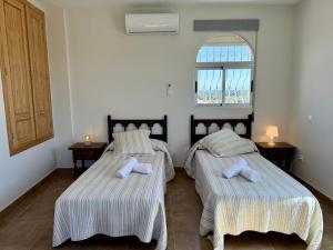 two beds in a room with a window at Casa Generoso en Navalcán in Navalcán +33 photos