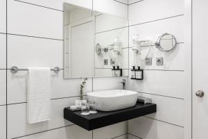 a white bathroom with a sink and a mirror at Parador de Ceuta in Ceuta