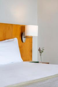 a bedroom with a white bed with a lamp at Parador de Ceuta in Ceuta