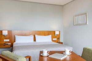 a hotel room with a bed and a table and chairs at Parador de Ceuta in Ceuta +141 photos
