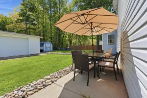 a table and chairs under an umbrella on a patio at Lake Rd E- Geneva in Geneva +50 photos