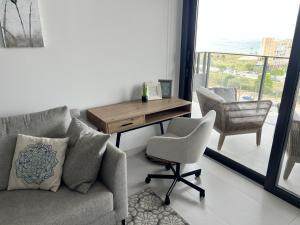 a living room with a couch and a desk and a chair at Apartment-de-la-luz-calpe in Calpe