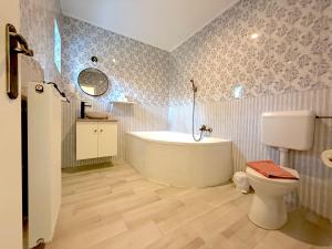 a bathroom with a tub and a toilet and a sink at Villa Harmónia in Gyula +104 photos