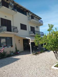 a large white building with balconies and a patio at EMINI Hotel in Durrës