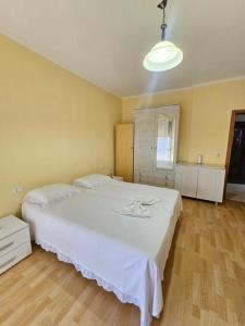 a bedroom with a large white bed in a room at EMINI Hotel in Durrës