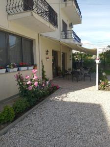 a house with a patio with flowers and a balcony at EMINI Hotel in Durrës