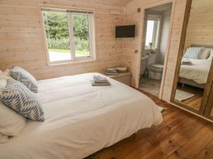 a bedroom with a white bed and a bathroom at Mallard in Ross on Wye
