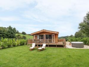 a wooden cabin with chairs and a table in a yard at Mallard in Ross on Wye