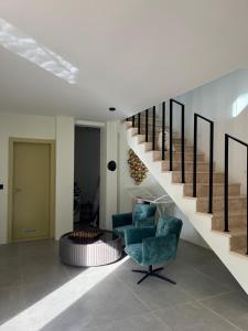 a living room with two chairs and a spiral staircase at Vila panorama in Budva